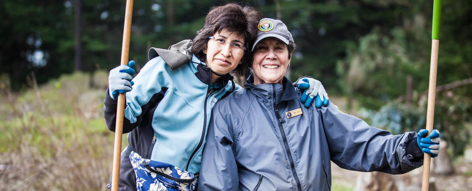 Two female volunteers with shovels.